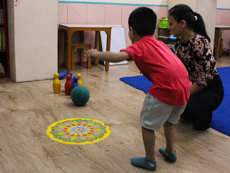 Indian child sitting calmly with noise-cancelling headphones in a softly lit room, representing sensory processing support for autism